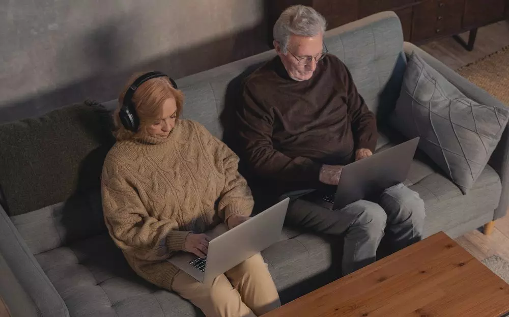 old couple using laptops